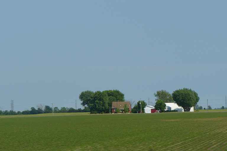 House and barn across a field.
