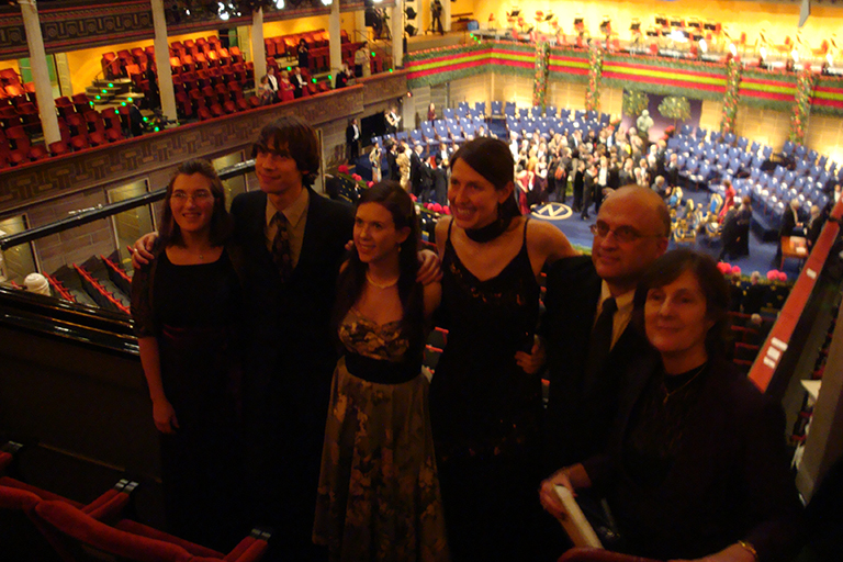 Art Ragauskas poses with several people in the balcony seating area in front of a stage.
