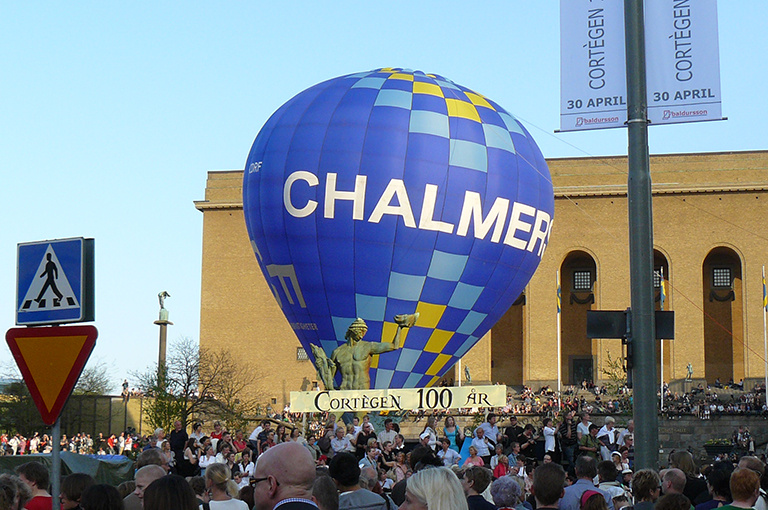 Crowded street that includes a hot air balloon reading "Chalmers."