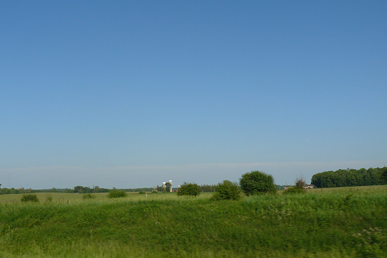 Silos and a barn seen at a distance.